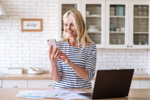 Smiling middle aged woman using smartphone